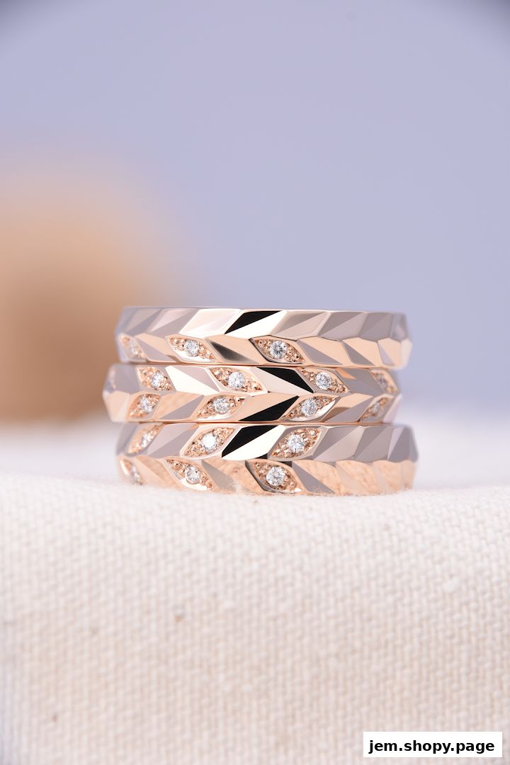 A stack of three rose gold rings with diamond accents, displayed on a textured fabric.