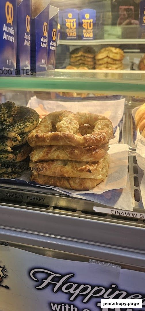 A display case filled with various pretzels from Auntie Anne's, including almond crunch and cheesy turkey.