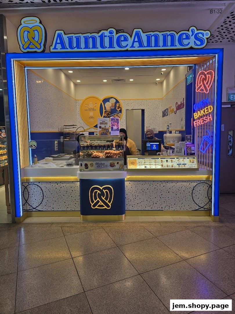 Auntie Anne's pretzel shop with a bright blue and yellow facade and neon signage.