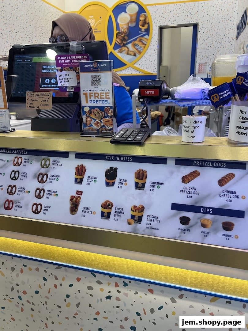 Auntie Anne's pretzel shop counter with a menu board displaying various pretzel items and dips.