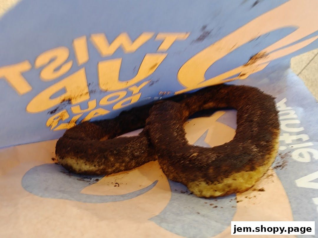 A close-up of a pretzel with chocolate powder inside an Auntie Anne's bag.