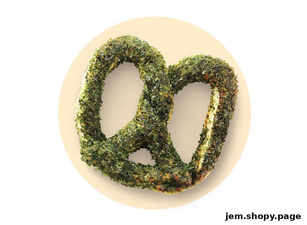 A close-up shot of a pretzel covered in green herbs, presented on a light background.