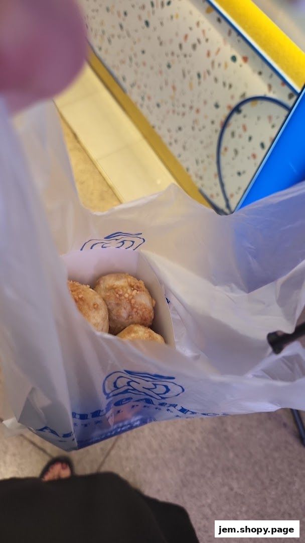 A white plastic bag from Auntie Anne's containing several pretzel bites.