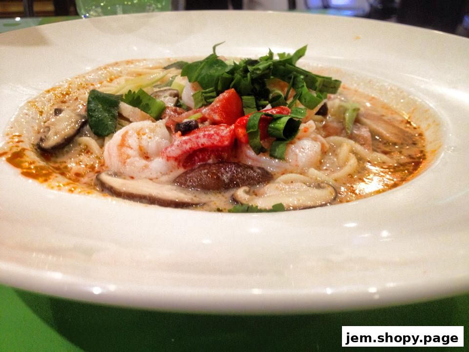 A close-up shot of a delicious Thai noodle soup with shrimp and mushrooms.