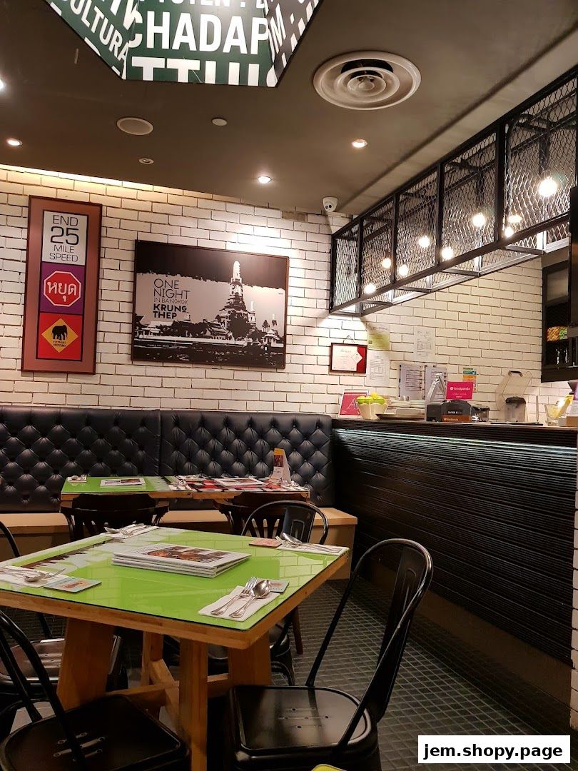 Interior of a Thai restaurant with tables set for dining and a counter area.