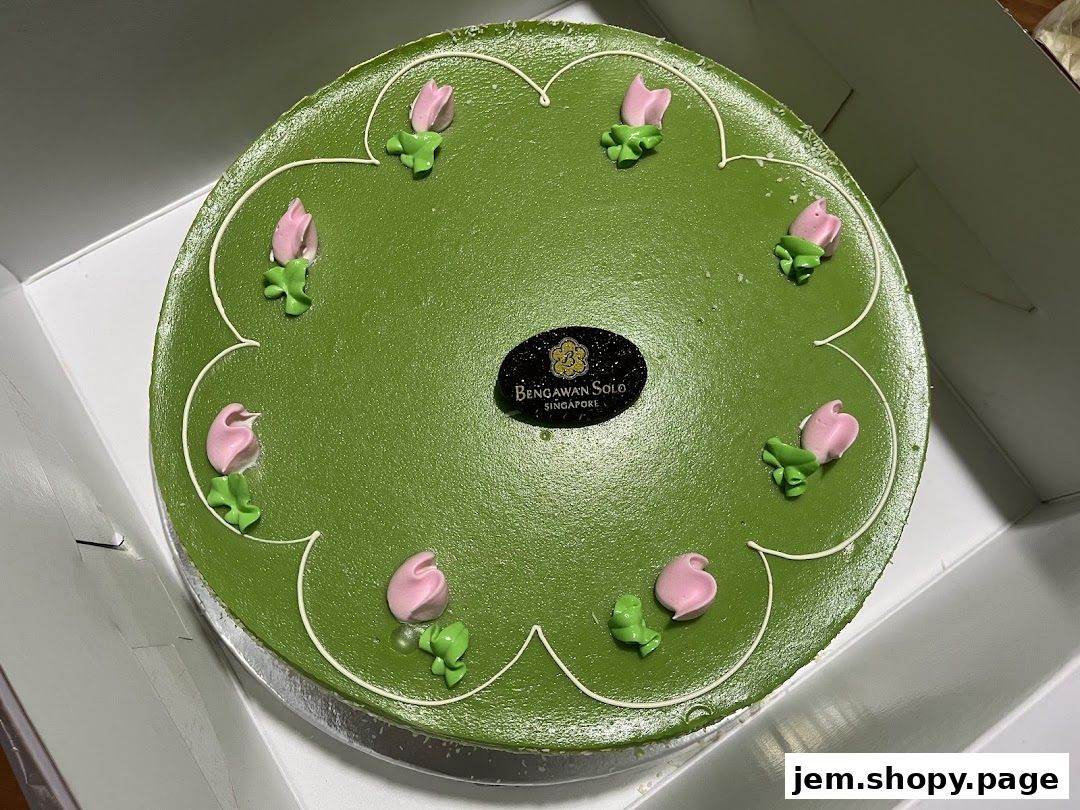 A green cake with pink floral decorations and the Bengawan Solo logo.