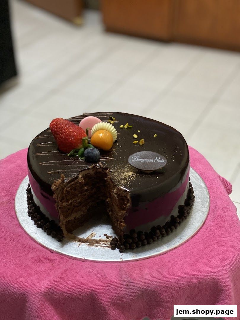 A decadent chocolate cake with fresh fruit and chocolate decorations.