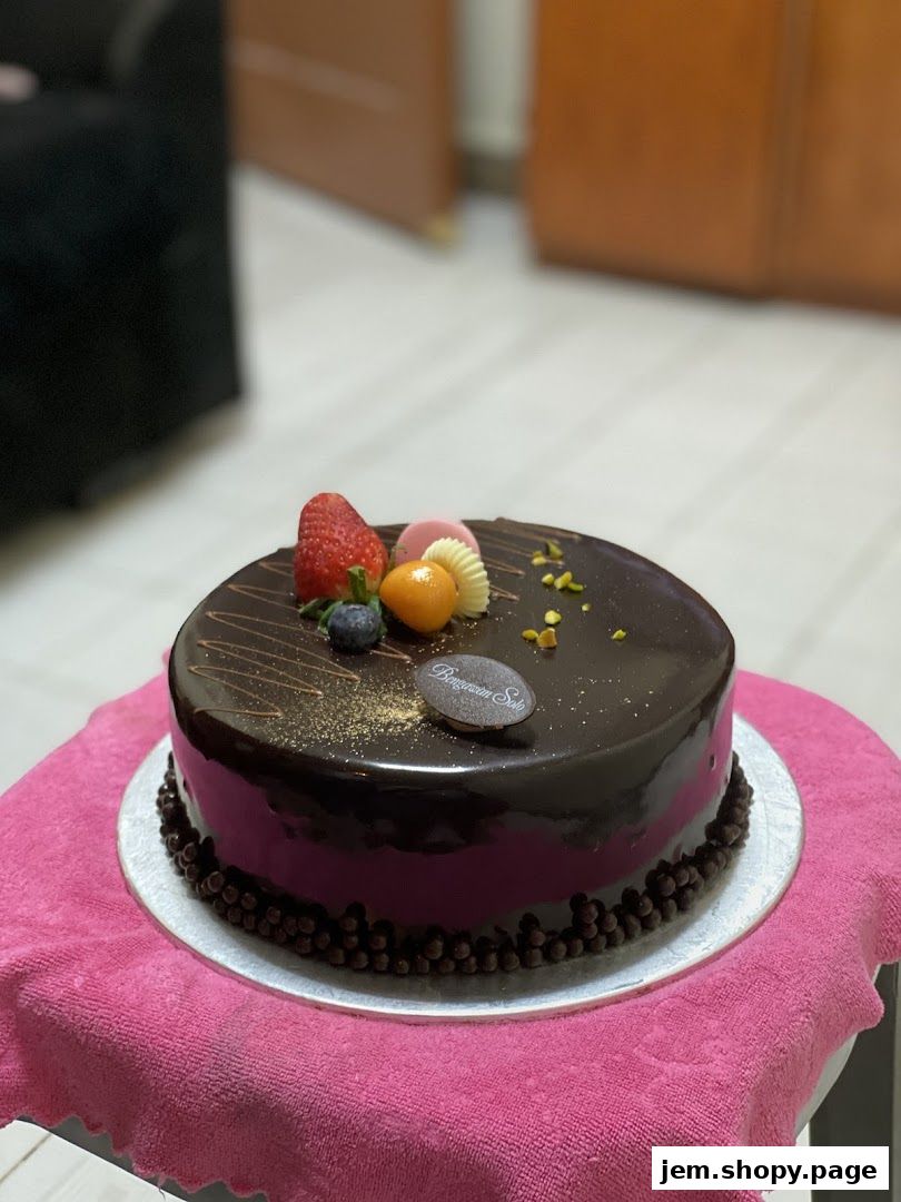 A decadent chocolate cake with fresh fruit and chocolate decorations.