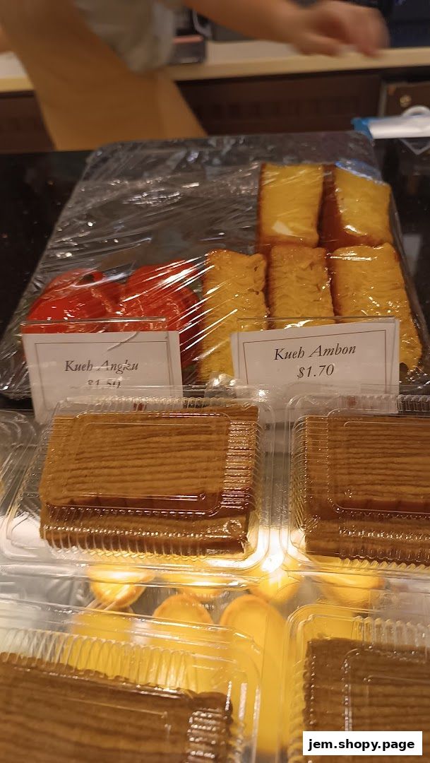 Assortment of traditional Indonesian kueh and cakes displayed in plastic containers.