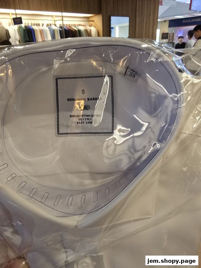 A close-up of a white Benjamin Barker shirt packaged in plastic, showing its label.