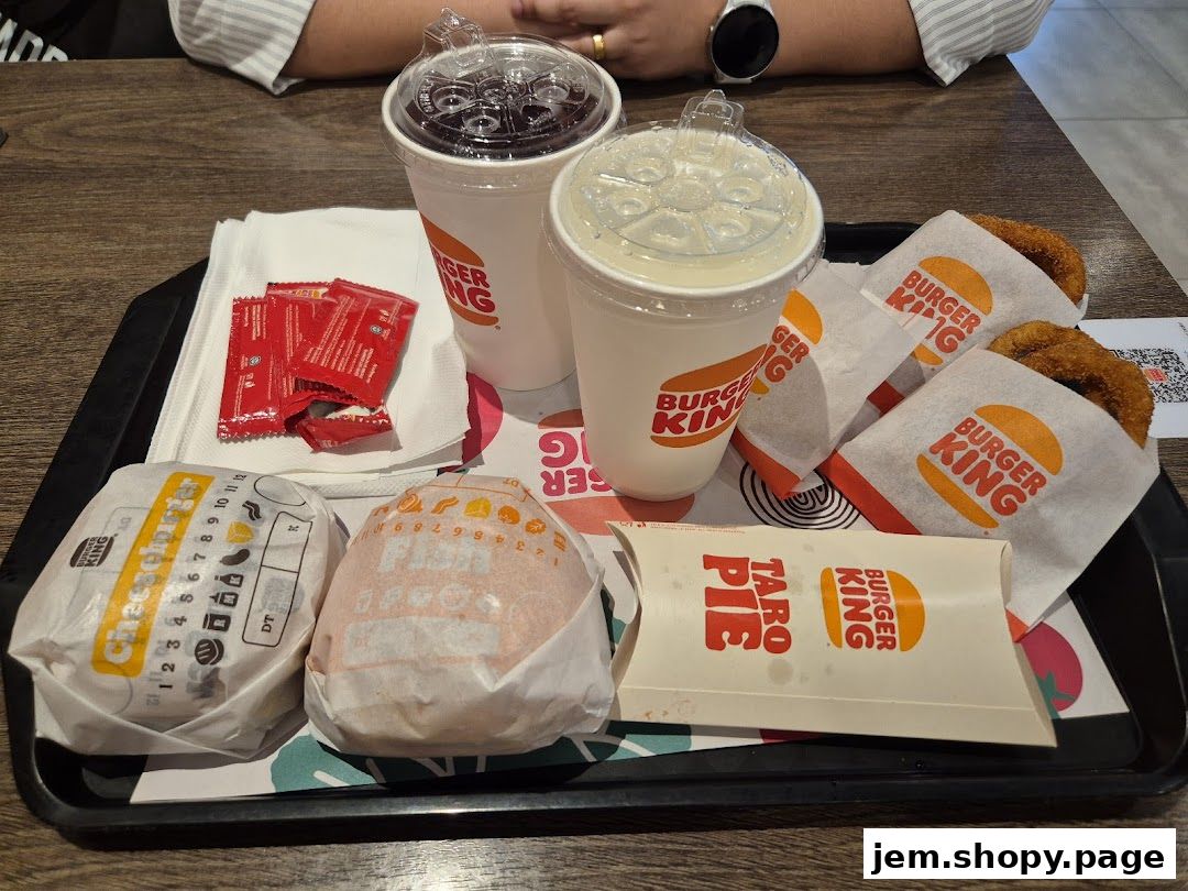 A tray of Burger King food including burgers, drinks, and a taro pie.