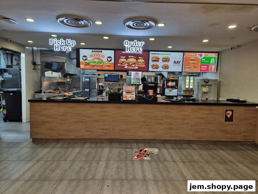 Burger King counter with digital menus displaying food items and prices.