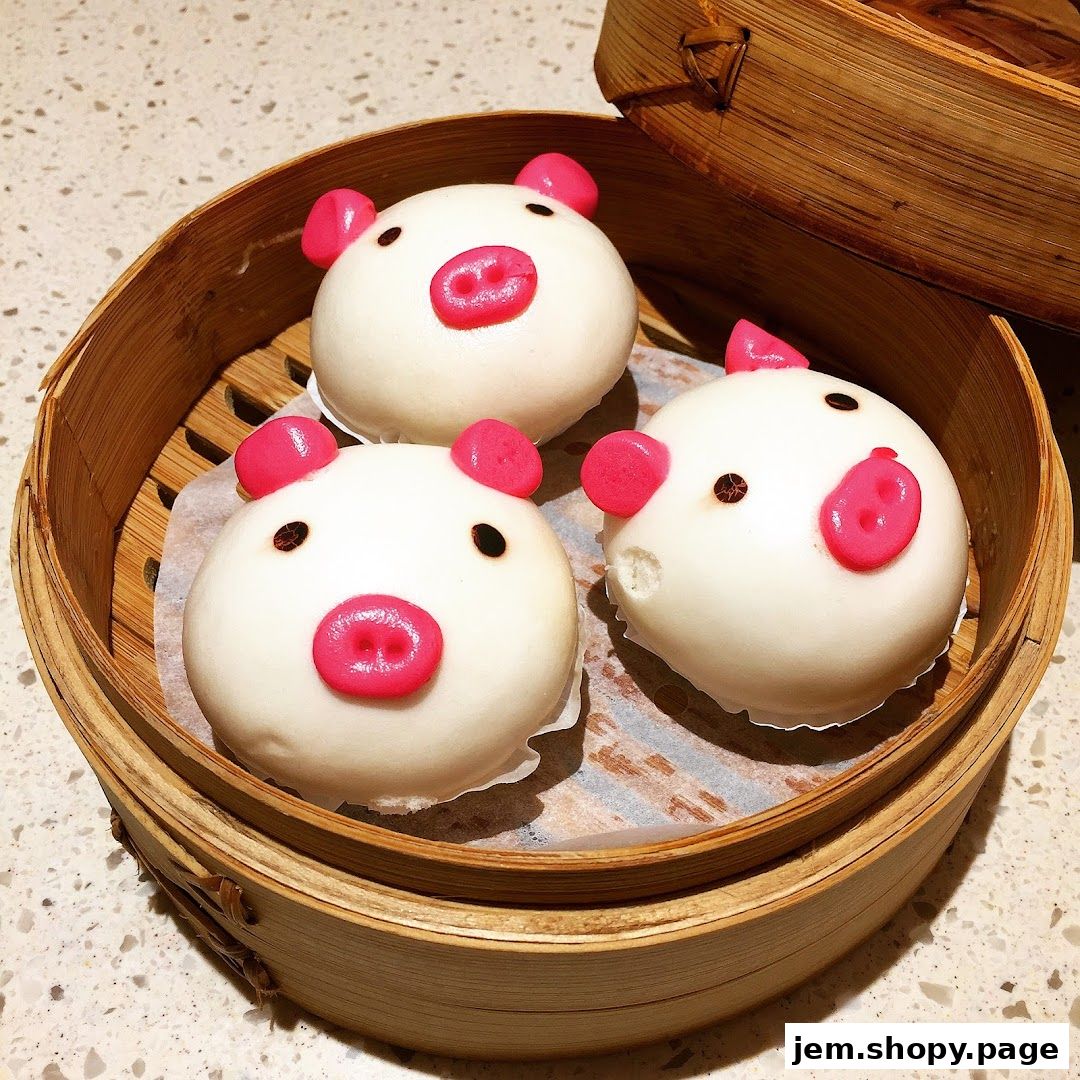 Three adorable pig-shaped steamed buns served in a bamboo steamer.