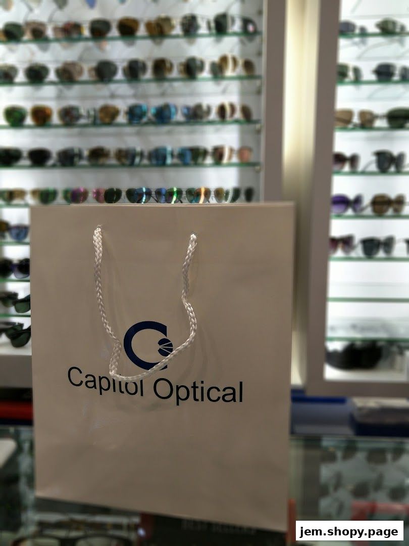 A shopping bag with Capitol Optical logo in front of shelves of eyeglasses.