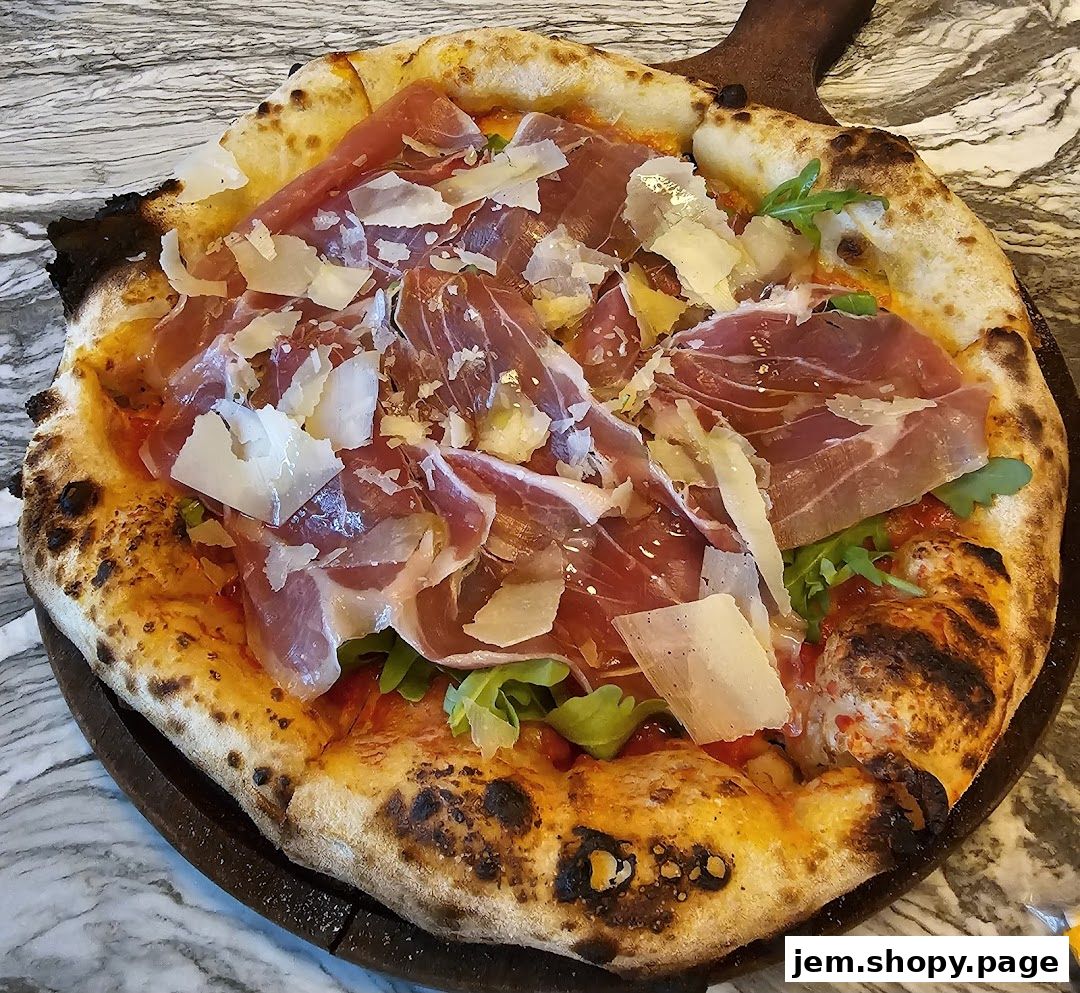 A delicious pizza topped with prosciutto and shaved parmesan cheese on a wooden board.