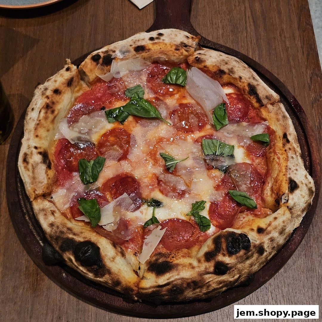 A delicious pepperoni pizza with basil and cheese on a wooden board.