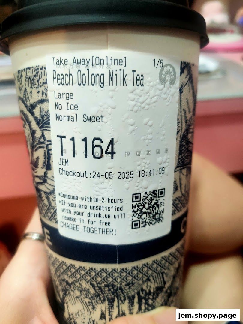 A close-up of a CHAGEE Peach Oolong Milk Tea cup with order details.