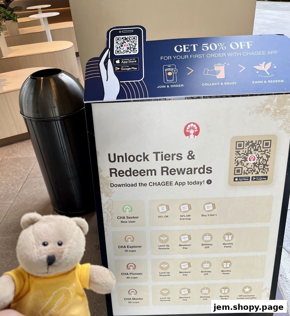 A promotional stand for CHAGEE app rewards, featuring a teddy bear.