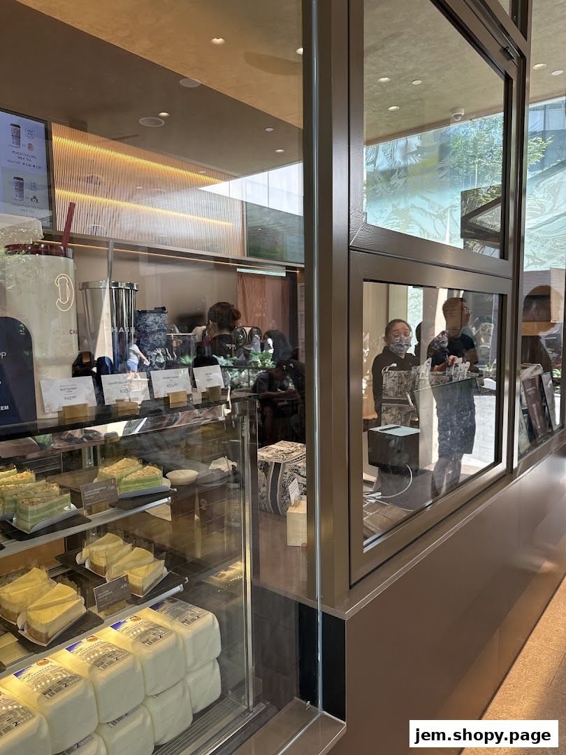 A display case filled with cakes and pastries at a CHAGEE shop.
