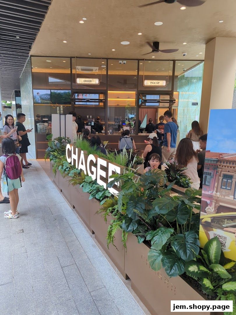 The exterior of a modern tea shop with a prominent 'CHAGEE' logo and lush greenery.