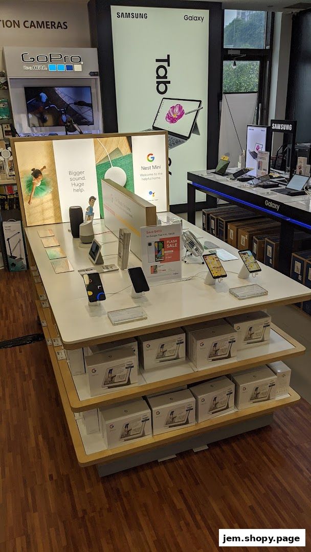 A retail store display featuring Google Nest Mini, smartphones, and Samsung Galaxy tablets.