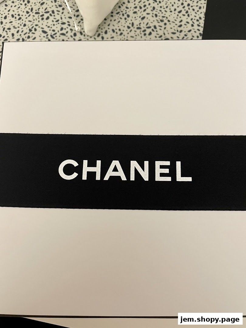 A close-up of a white Chanel shopping bag with the iconic logo.