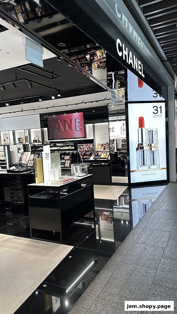 Interior view of a Chanel beauty store with makeup displays and a large lipstick advertisement.