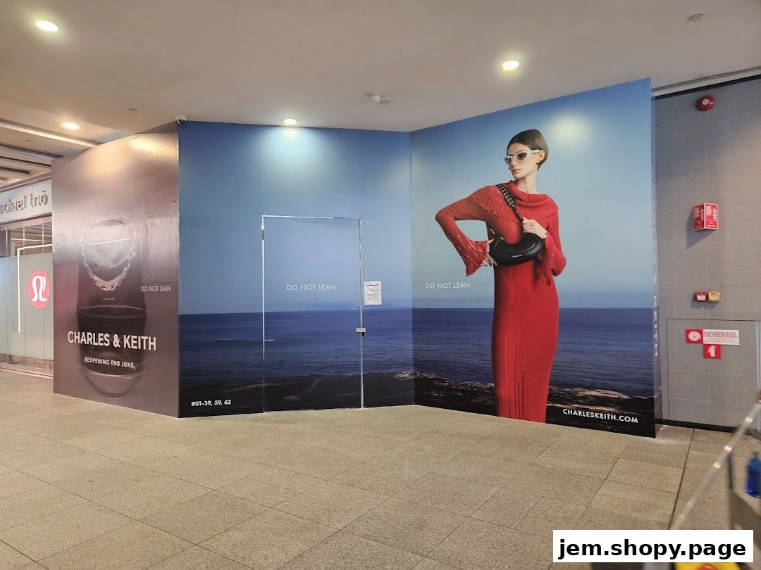 Charles & Keith shop front with a large advertisement featuring a model in a red dress.