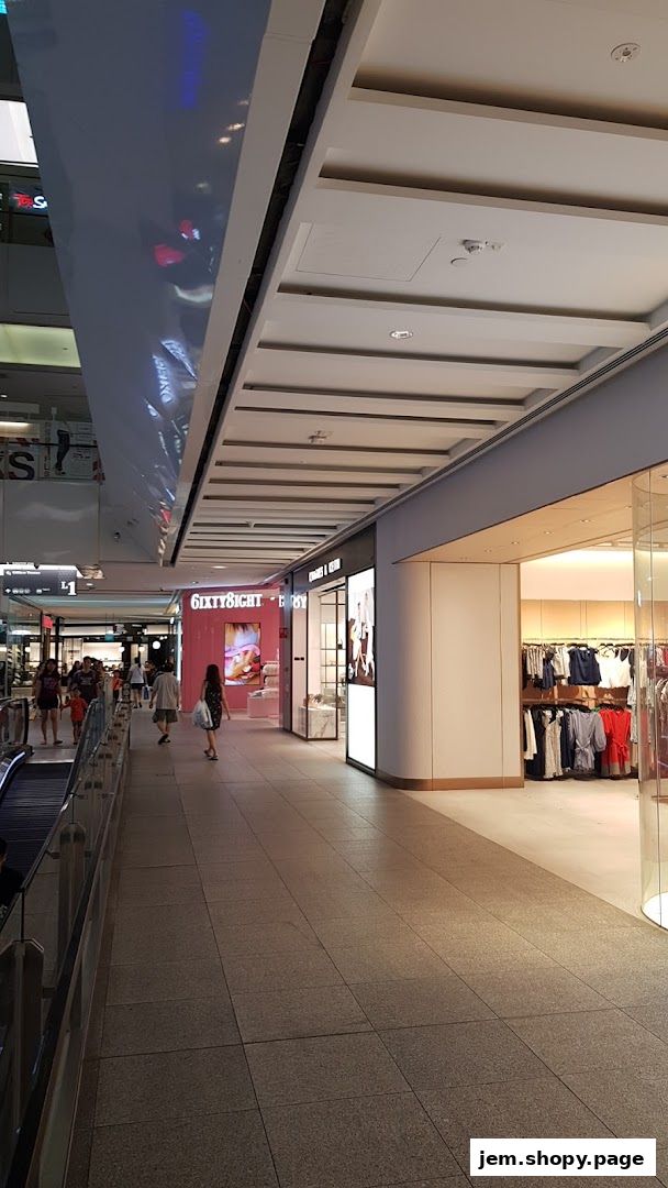 A view of a shopping mall corridor with several retail stores, including Charles & Keith.