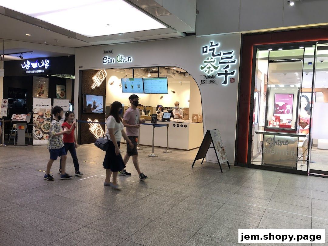 People walking past a CHICHA San Chen bubble tea shop in a mall.