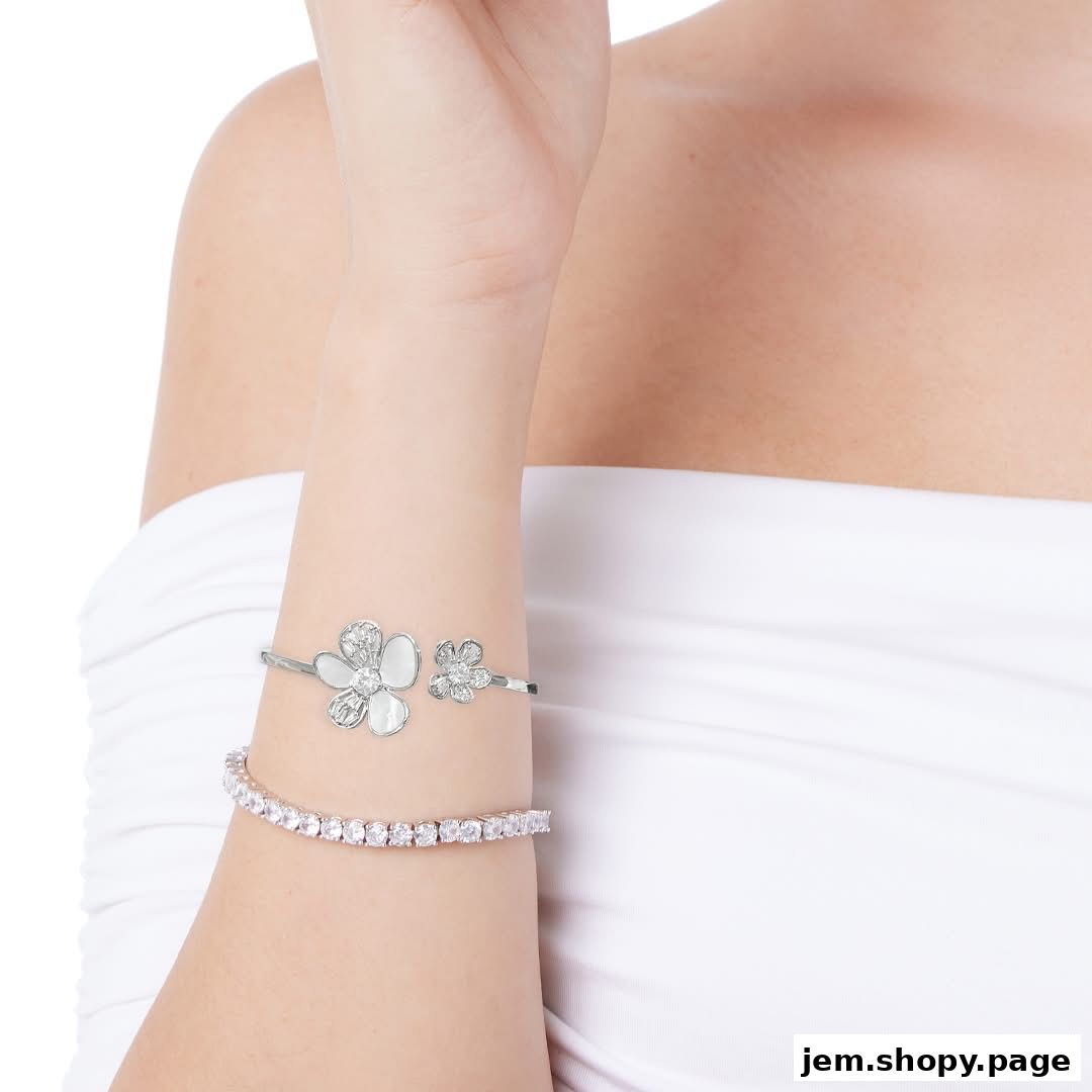 A woman's arm adorned with two elegant bracelets, one floral and one with sparkling stones.