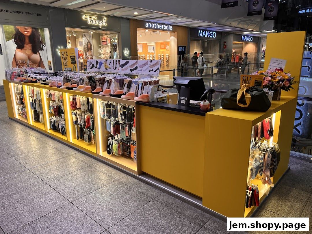 A bright yellow retail kiosk displaying a wide variety of socks and hosiery.