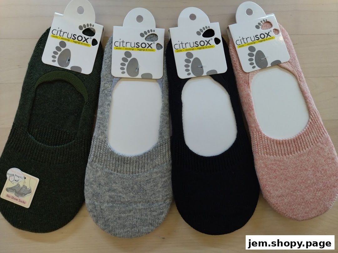 Four pairs of Citrusox no-show socks in various colors displayed on a wooden surface.