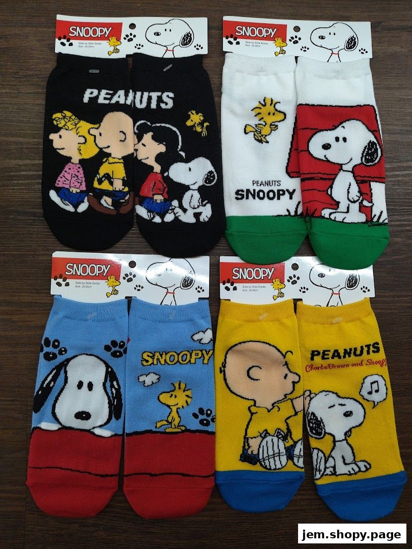A collection of Snoopy and Peanuts themed socks displayed on a wooden surface.