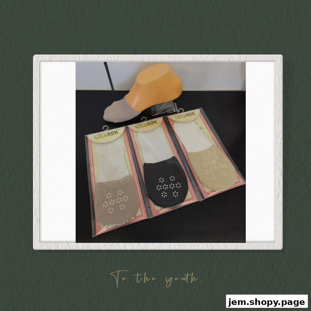 Packaged no-show socks with floral patterns displayed on a mannequin foot.