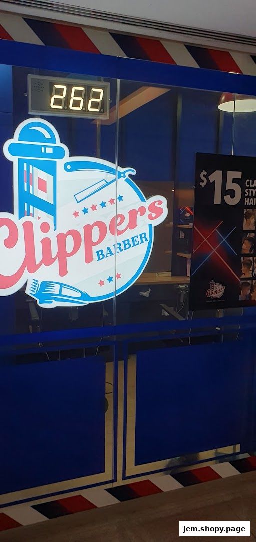 The entrance of Clippers Barber shop with its logo and a price display.
