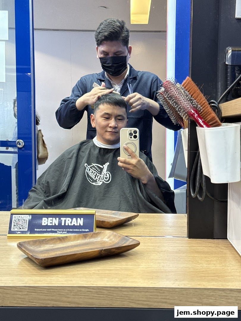 A barber is cutting a customer's hair in a modern barber shop.