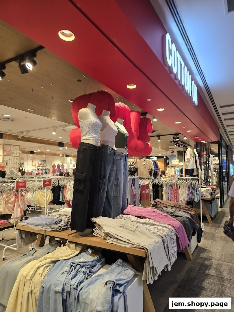 Mannequins display casual outfits in front of a Cotton On store with clothing racks visible.