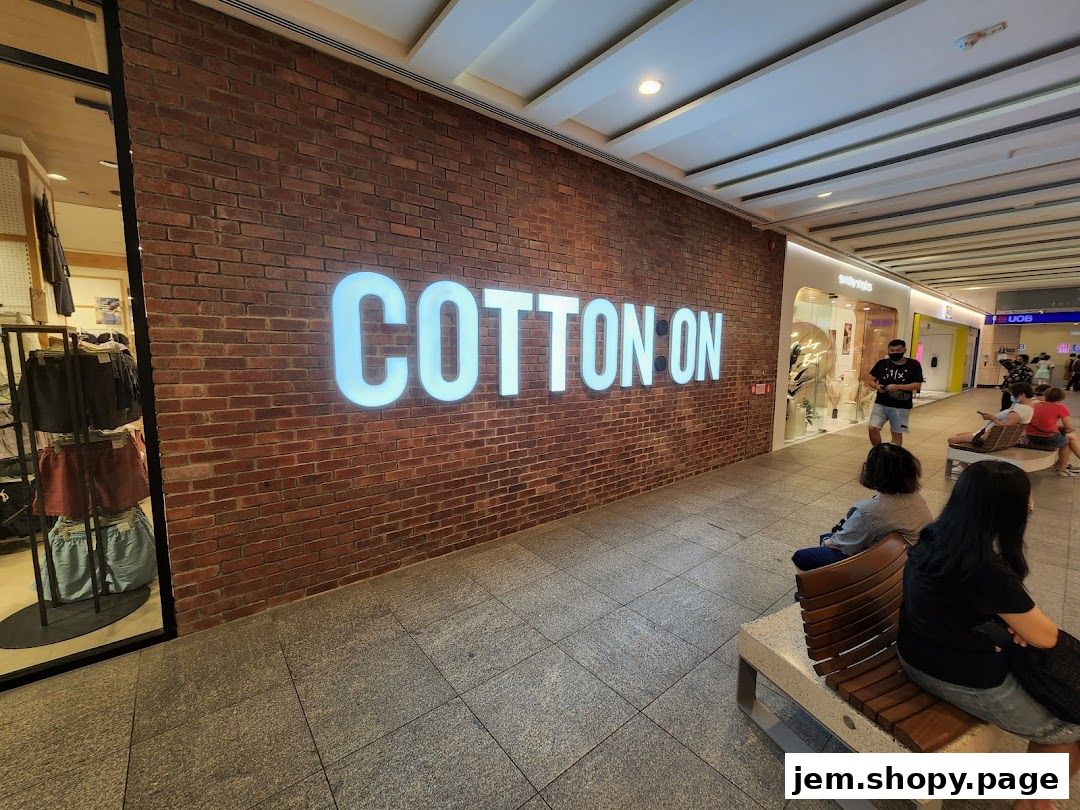 The Cotton On store entrance with a large illuminated sign on a brick wall.