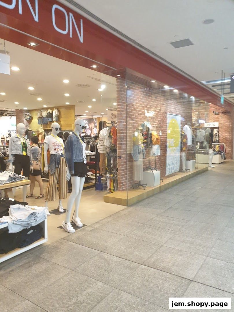 The exterior of a Cotton On clothing store with mannequins displaying outfits in the window.