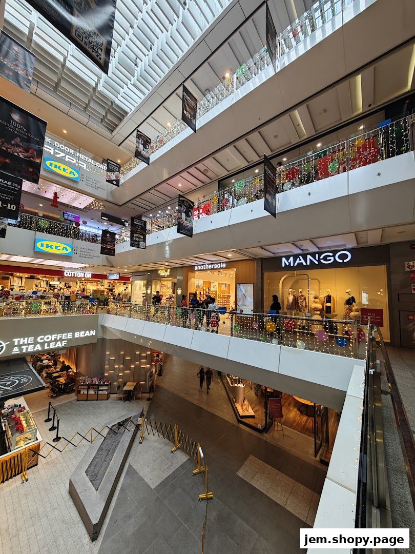 Interior view of a multi-level shopping mall with various stores and escalators.