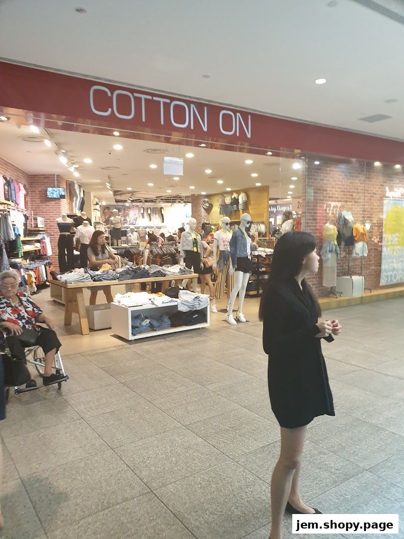 The Cotton On store entrance with mannequins displaying clothing and shoppers inside.