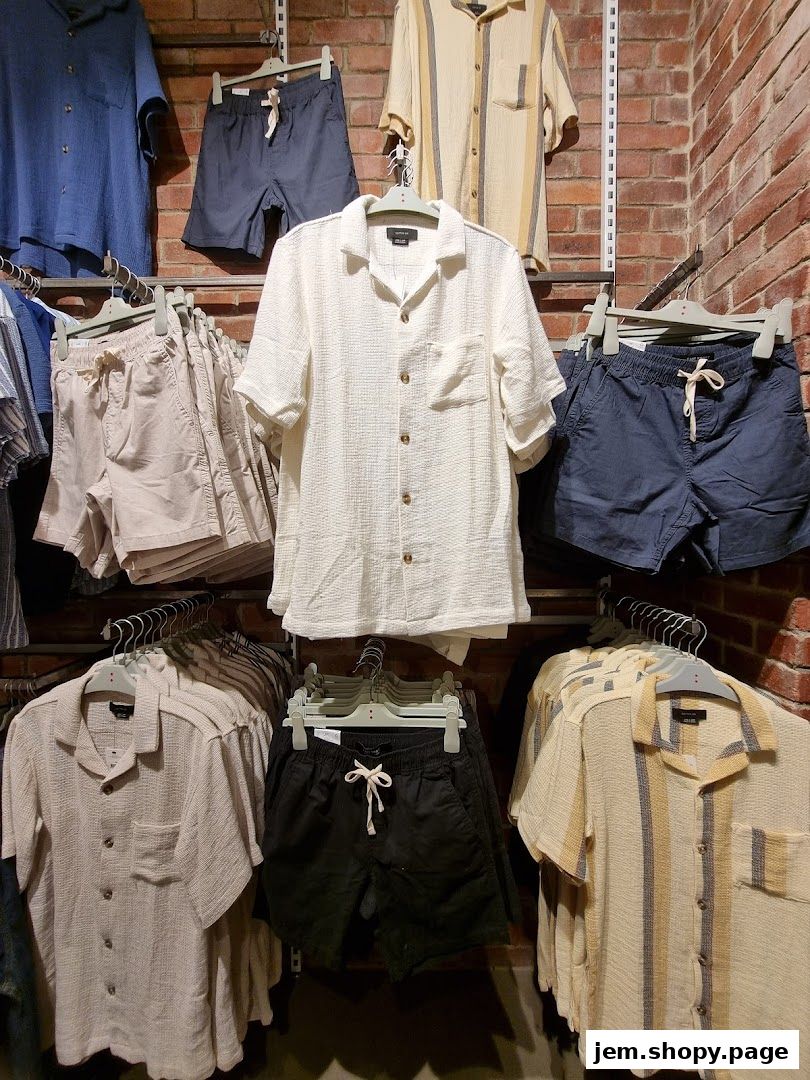 A display of men's casual shirts and shorts in various colors and patterns.