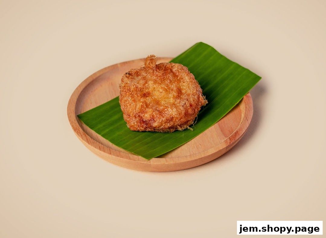 A golden-brown fried dish served on a banana leaf and a wooden plate.