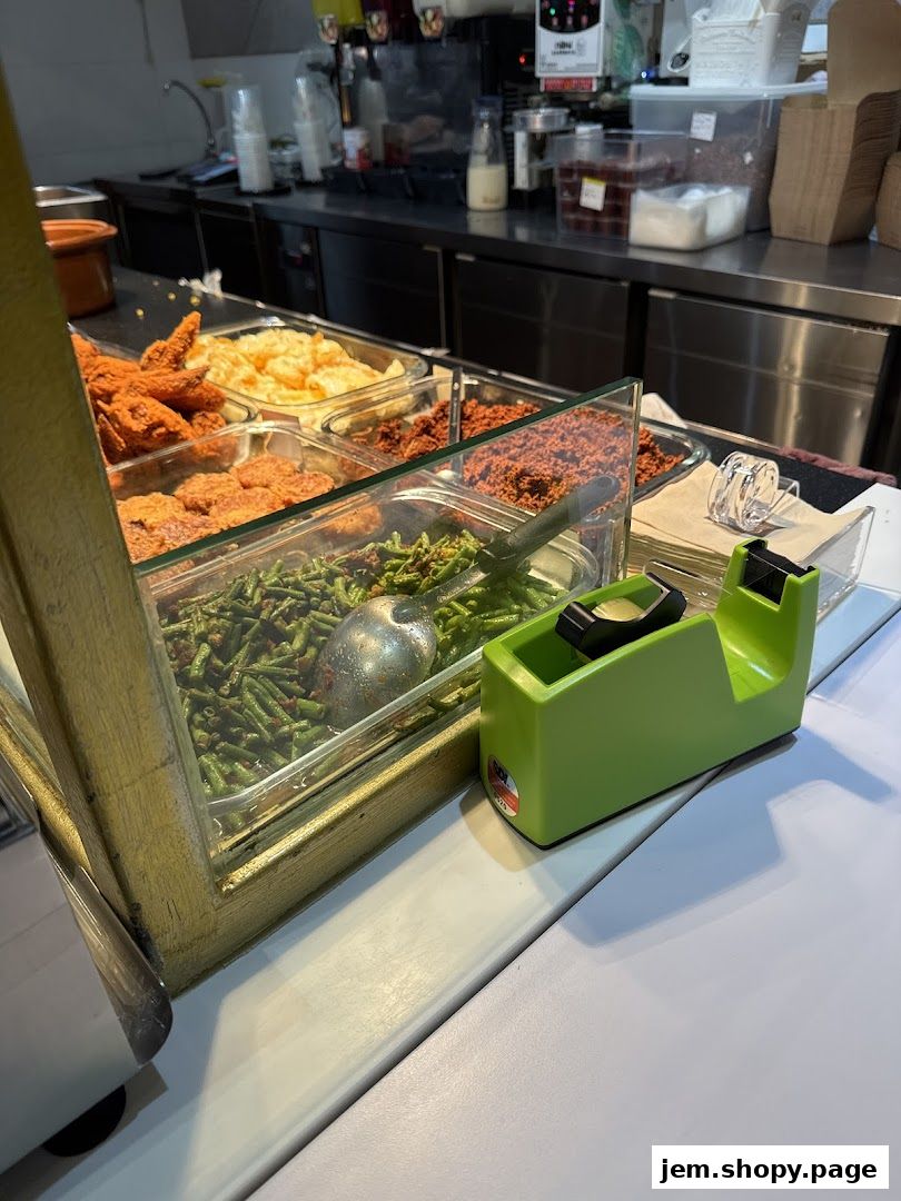 A display of various food items, including fried chicken and vegetables, at a food stall.