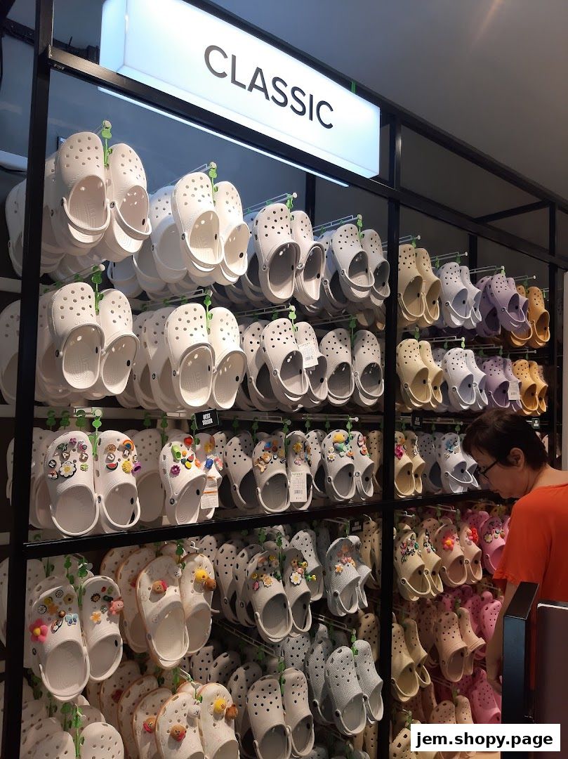 A display of various Crocs shoes in different colors and styles, including classic clogs and decorated options.