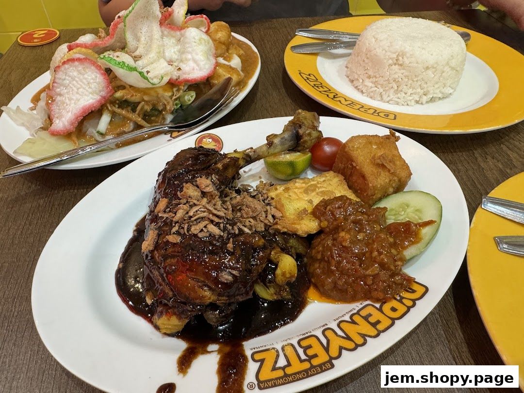A close-up of a delicious meal featuring roasted duck, rice, and various side dishes.