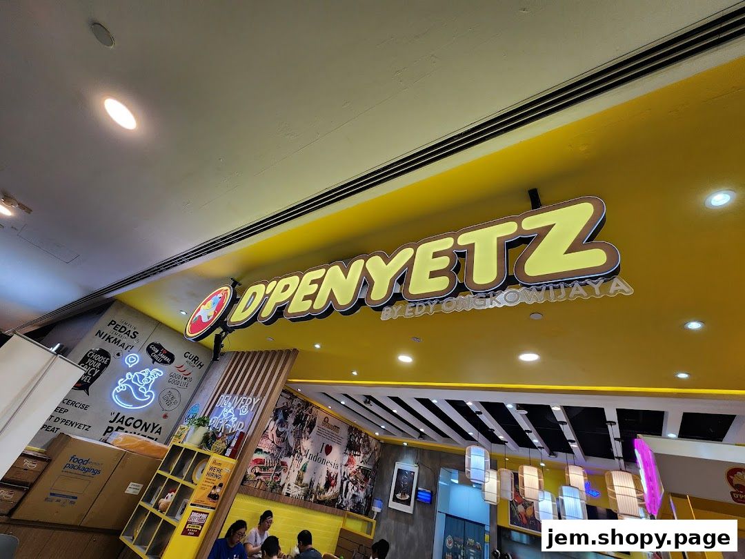 The exterior of a brightly lit restaurant called D'PENYETZ, featuring a prominent yellow sign.