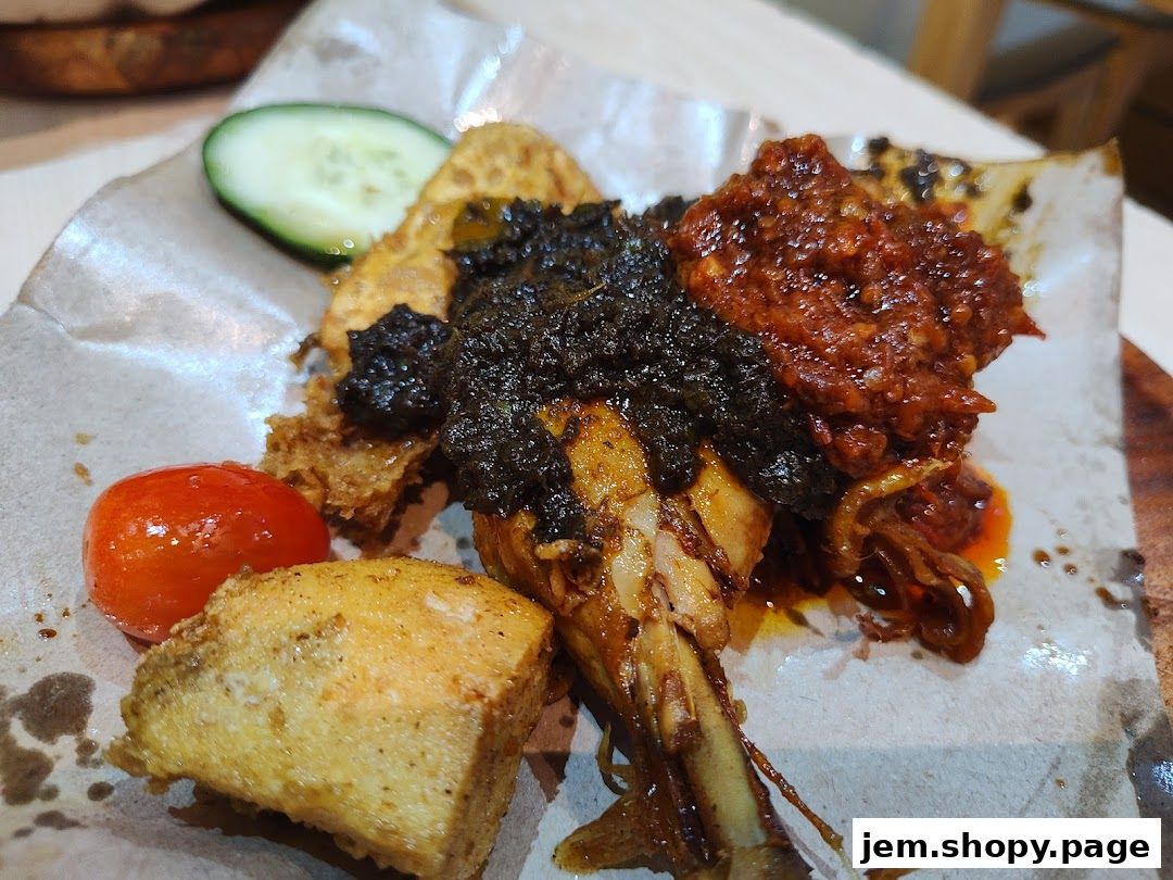 A close-up of a delicious Indonesian dish with chicken, tofu, tomato, and cucumber.