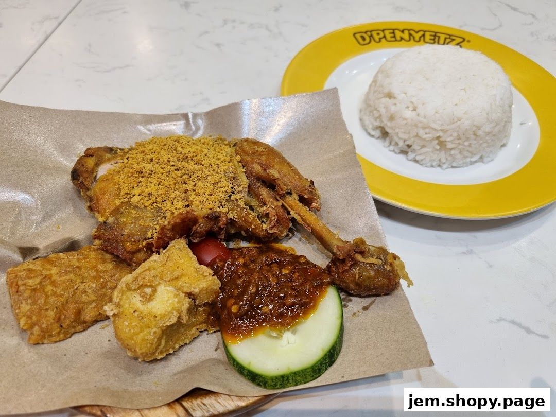 A plate of fried chicken with rice, tofu, and sambal from D'Penyetz Jem.